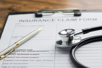 health insurance claim form with stethoscope on wood table selective focus
