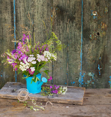 Wild field flowers bouquet over wooden background