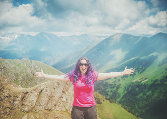 Naklejka na ściany i meble Happy woman hiker standing on the top of mountain outdoor