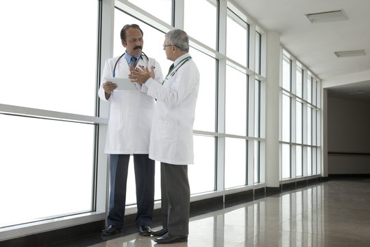 Two doctors talking in corridor of hospital