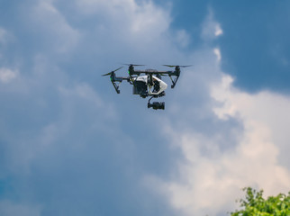 Drone in the blue sky. Quadrocopter hovered in the air.