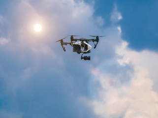 Drone in the blue sky. Quadrocopter hovered in the air.