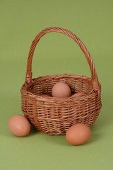Kurze jajka w wiklinowym koszyku na zielonym obrusie © Ewa Oderkiewicz