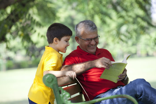 Grandfather and grandson looking a book