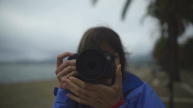 Girl photographer adjusting lens on camera, taking pictures at leisure, hobby