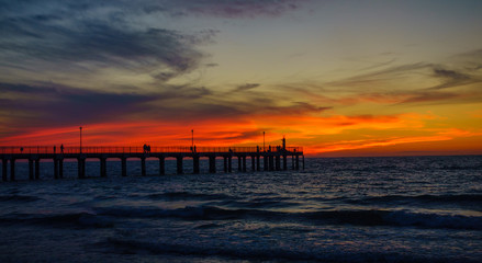 Fototapeta na wymiar People walking on the pier at sunset