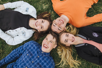 Teenagers lie on the grass after school.