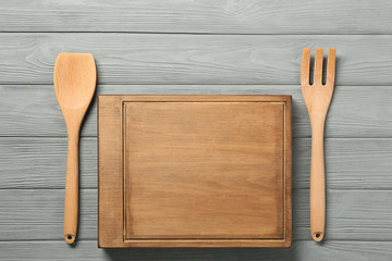 Board and utensils on wooden background