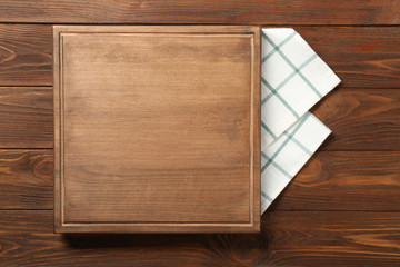 Composition of board and napkin on wooden background