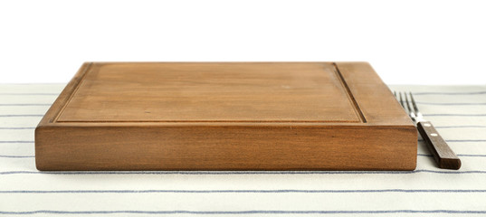 Wooden board and fork on tablecloth against white background