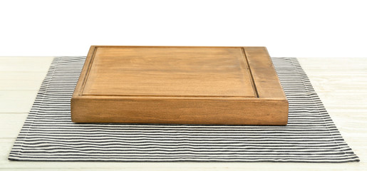 Wooden board on table with napkin against white background
