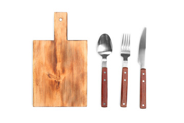 Wooden board and cutlery on white background