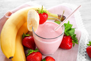 Glass of delicious strawberry and banana homemade smoothie on napkin