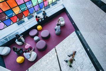 Overhead view of people meeting and working in lobby of office - obrazy, fototapety, plakaty