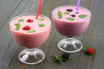 Healthy raspberries and blackberries yogurt with fresh berries on dark wooden background