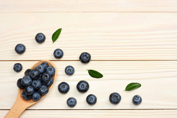 Naklejka na ściany i meble blueberries in wooden spoon on light wooden table background. top view with copy space