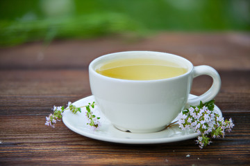 porcelainl cup with green tea on table