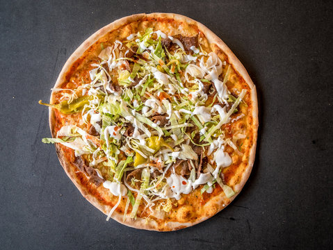 Kebab pizza on dark rustic background. Top view from above.