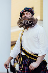 Handsome portrait of a brave Scot with a amazing beard and mustache curls in the Hungarian style.