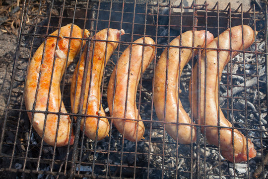 Appetizing Fresh Sausages Cooked At Stake Outdoors