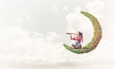 Concept of careless happy childhood with girl on green moon