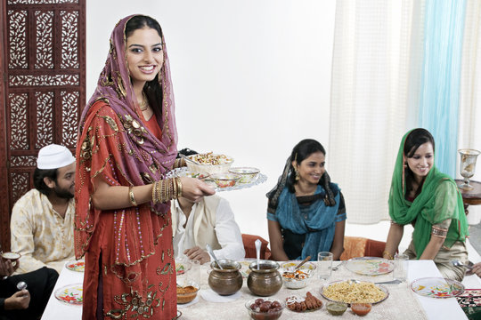 Muslim woman serving food during Id 
