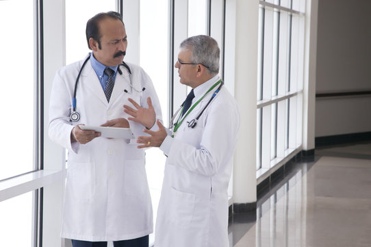 Two doctors talking in corridor of hospital