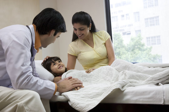 Doctor sitting with a little girl and her mother 