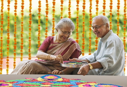 Old couple making a rangoli 