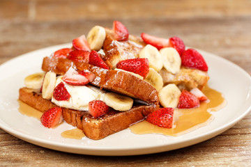 Dessert routons with strawberries, bananas and ice cream with honey