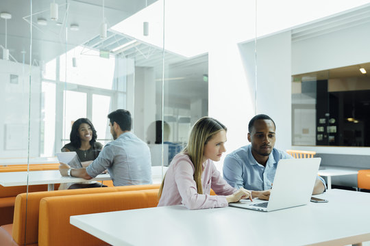 Coworkers Meeting In Groups In Modern Office Space