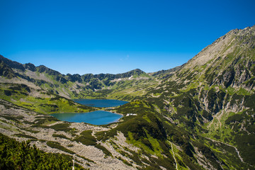 Obraz premium Tatras mountains, Valley of five ponds. View on mountains and two lakes. Trail to see eye from the mountain hostel in five ponds. Five breathtaking mountain lakes in the High Tatras.