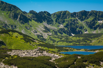 Naklejka premium Tatras mountains, Valley of five ponds. View on mountains and two lakes. Trail to see eye from the mountain hostel in five ponds. Five breathtaking mountain lakes in the High Tatras.