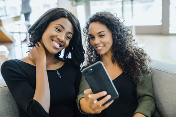 Women taking selfies with cell phone together