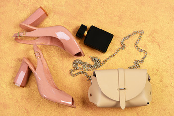 Fashion and beauty concept. Pair of pink shoes, beige handbag