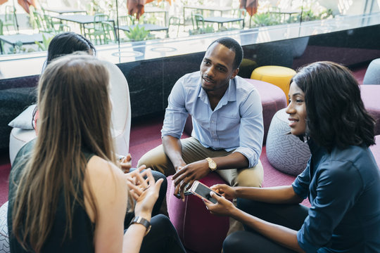 Business Meeting In Lobby Of Colorful Modern Office Space