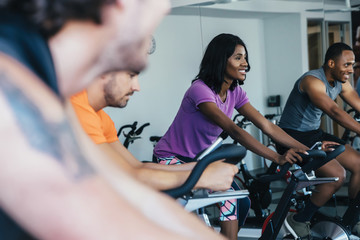 People cycling in a spin class at a gym