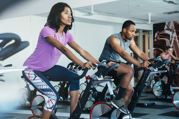 People cycling in a spin class at a gym