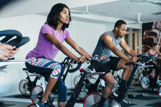 People cycling in a spin class at a gym