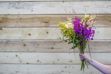 A bouquet of wild wildflowers in hands