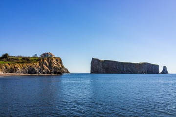 Fototapeta na wymiar Famous Rocher Perce rock in Gaspe Peninsula, Quebec, Gaspesie region with house on cliff