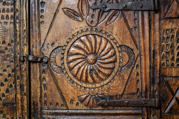 Old wooden engraved door on vintage furniture