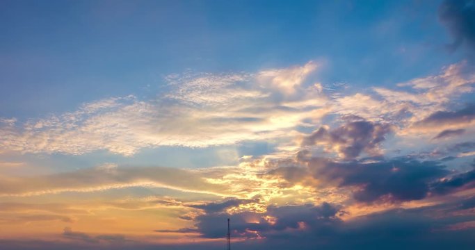 Time lapse clip of evening fluffy curly rolling clouds with setting sun
