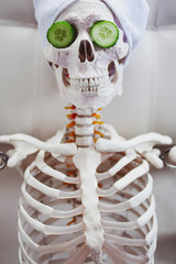 Skeleton in Spa salon with towel on her head and mask on her face, relaxes, care themselves. An...