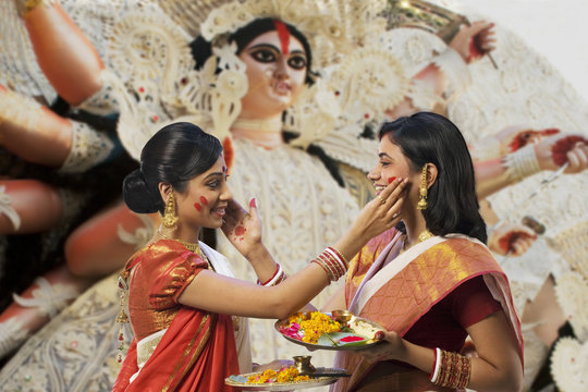 Bengali women putting colour on each others faces 