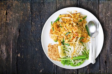 Stir-fried rice stick noodles with fresh shrimp on the wood table. Fresh and yummy Asian Thai style Urban food.