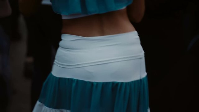 Close-up view of young couple dancing latin salsa dance on open air street festival. Man and woman having fun in crowd.