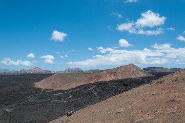 Fototapeta na wymiar Volcanic cone surrounded by ancient basaltic lava flows, Lanzarote, Canary Islands
