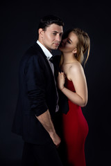Young couple in evening gown in black background