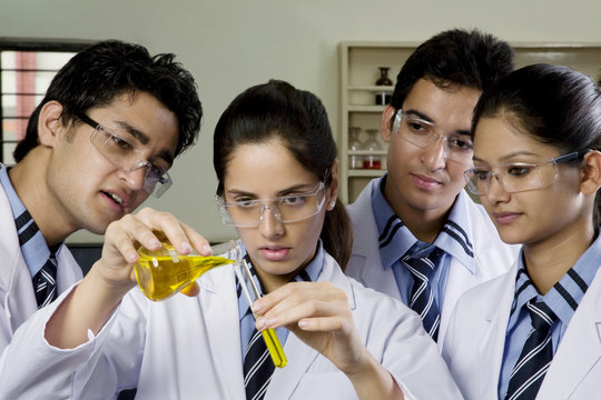 Girl pouring a liquid into a test tube 